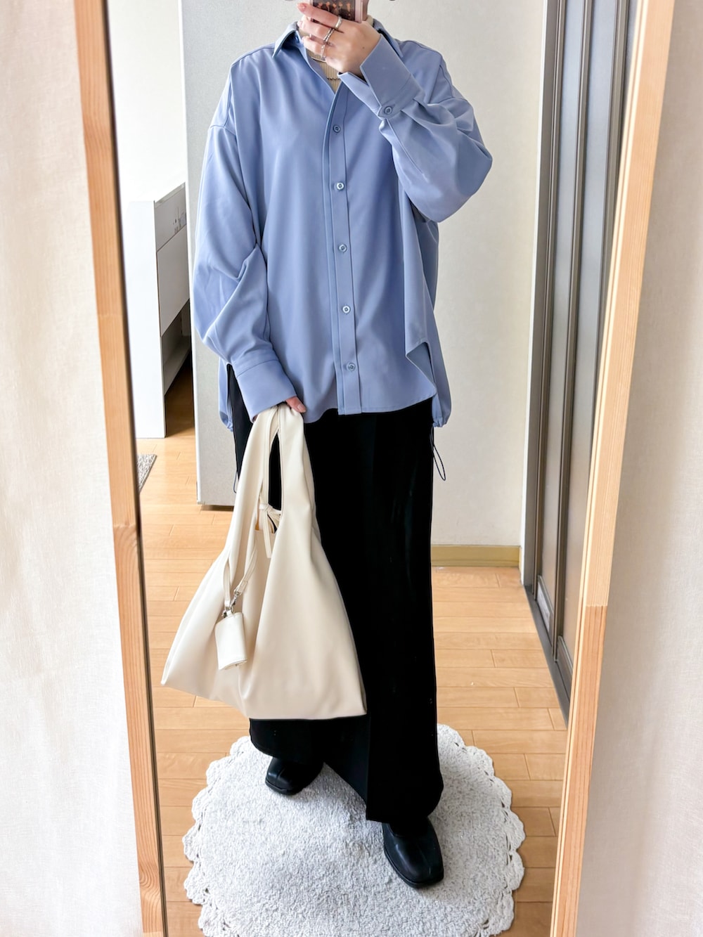 ブルー系のシャツ/ブラウス、ブラック系のスラックス、ホワイト系のトートバッグを着用したレディースの冬コーディネートの3枚目の写真