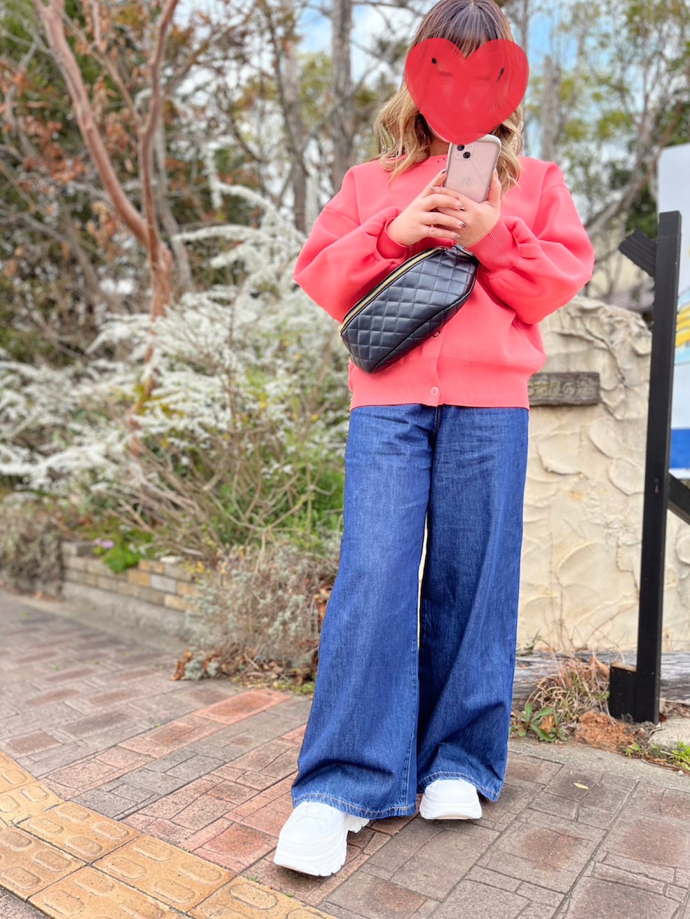 ブルー系のデニムパンツ、ピンク系のニット/セーターを着用したレディースの春コーディネートの2枚目の写真