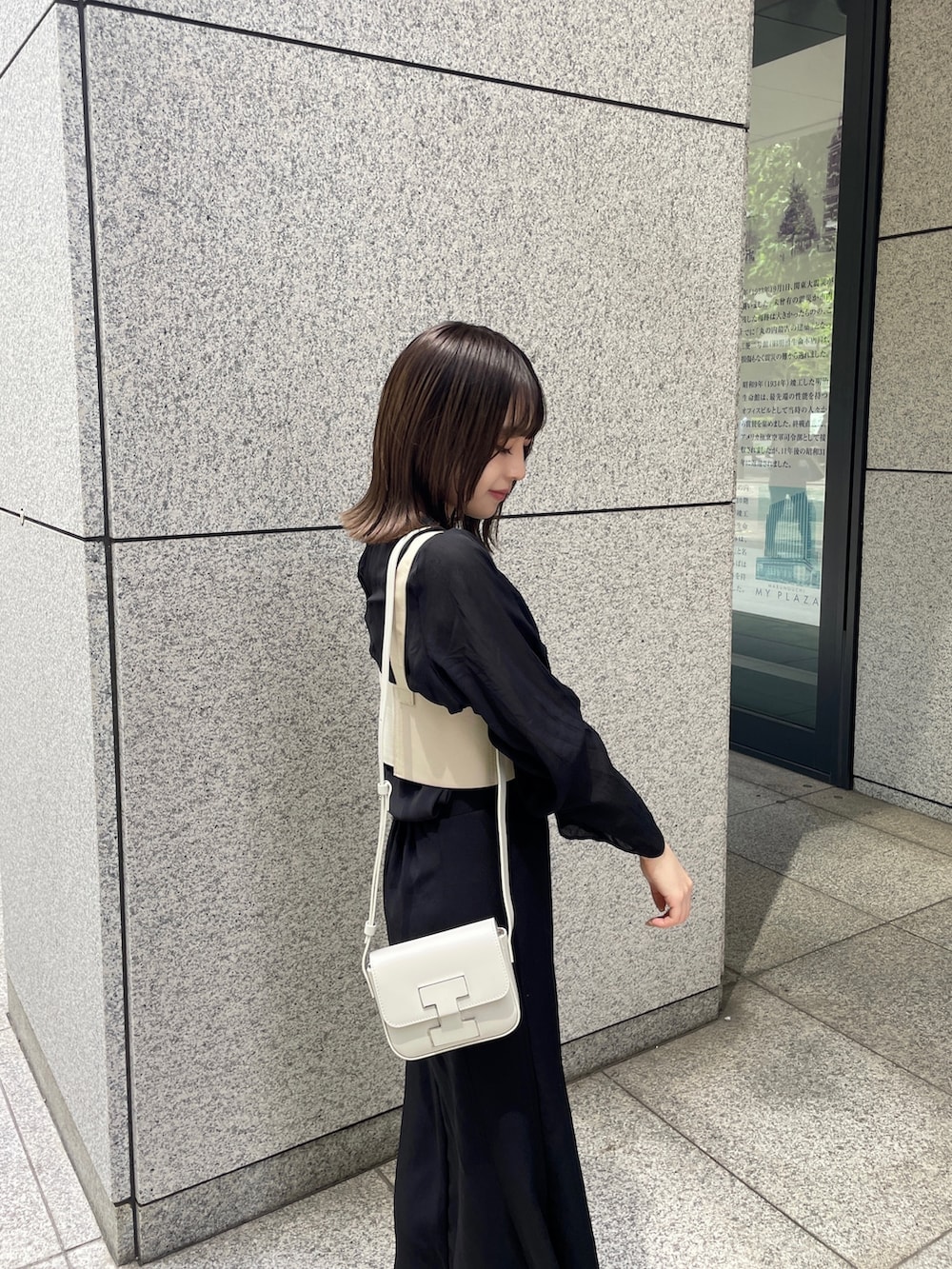 ホワイト系のショルダーバッグ、ブラック系のサンダル、ブラック系のシャツ/ブラウスを着用したレディースの春コーディネートの3枚目の写真
