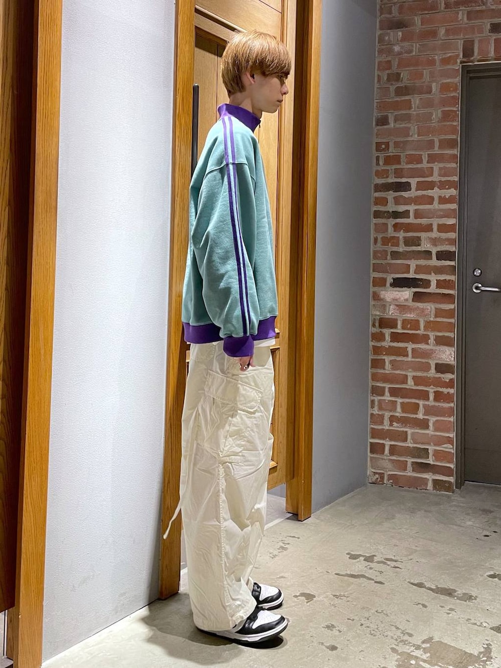 グリーン系のスウェット、ホワイト系のカーゴパンツを着用したメンズの春コーディネートの4枚目の写真