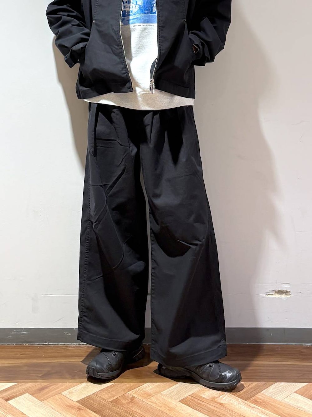 ブラック系のスニーカー、グレー系のスウェット、ブラック系のスラックスを着用したメンズの春コーディネートの4枚目の写真