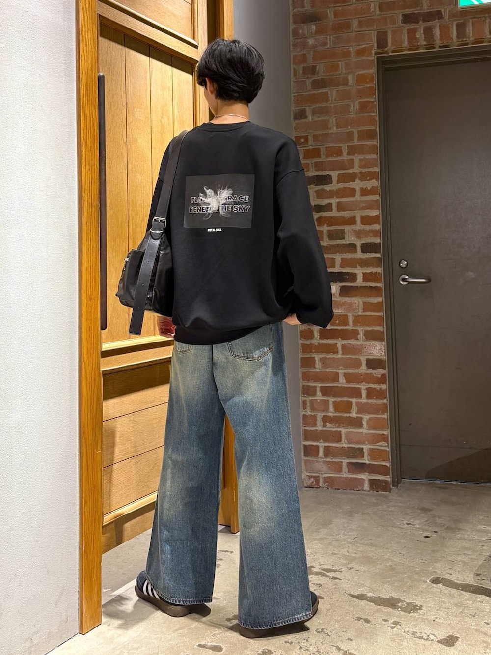 ブラック系のスニーカー、その他のショルダーバッグ、ブルー系のデニムパンツを着用したメンズの秋コーディネートの5枚目の写真