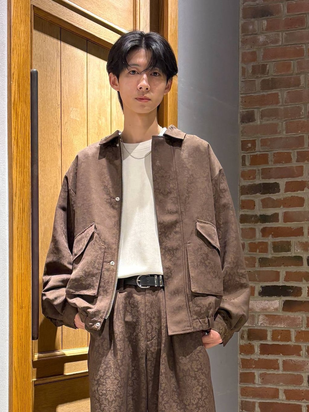 ホワイト系のスウェット、ブラック系のローファー、イエロー系のスラックスを着用したメンズの冬コーディネートの3枚目の写真