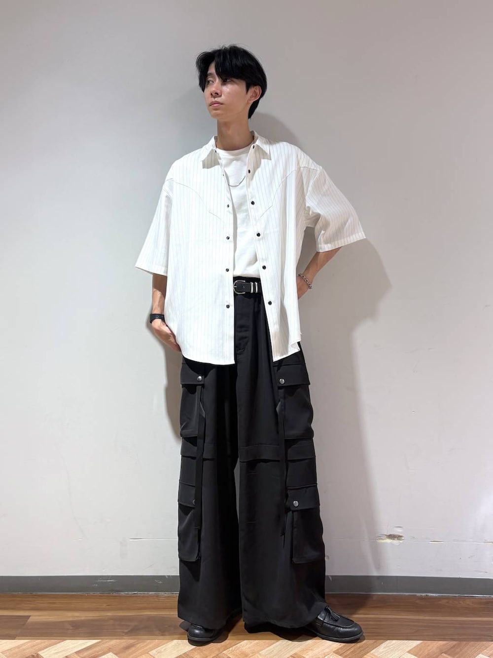ブラック系のローファー、ホワイト系のTシャツ/カットソー、ブラック系のカーゴパンツを着用したメンズの夏コーディネートの2枚目の写真