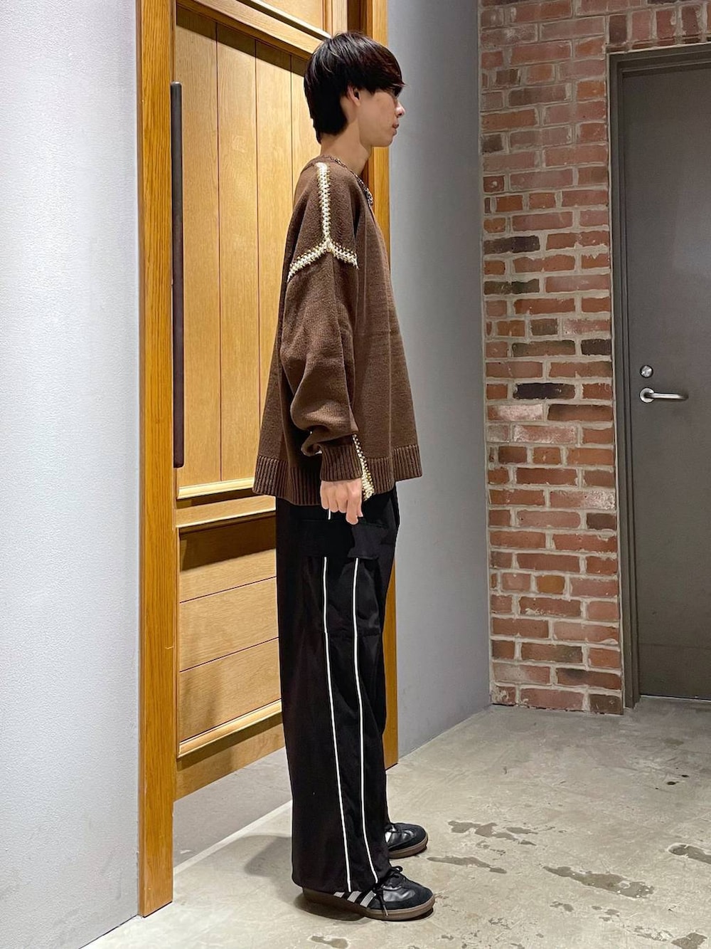 ブラック系のカーゴパンツ、ブラウン系のニット/セーターを着用したメンズの秋コーディネートの3枚目の写真