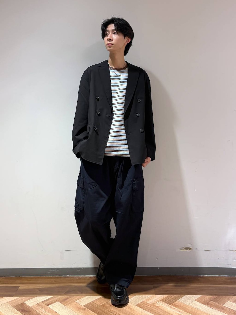 ブラック系のテーラードジャケット、ブラック系のローファー、ブルー系のTシャツ/カットソーを着用したメンズの春コーディネートの2枚目の写真