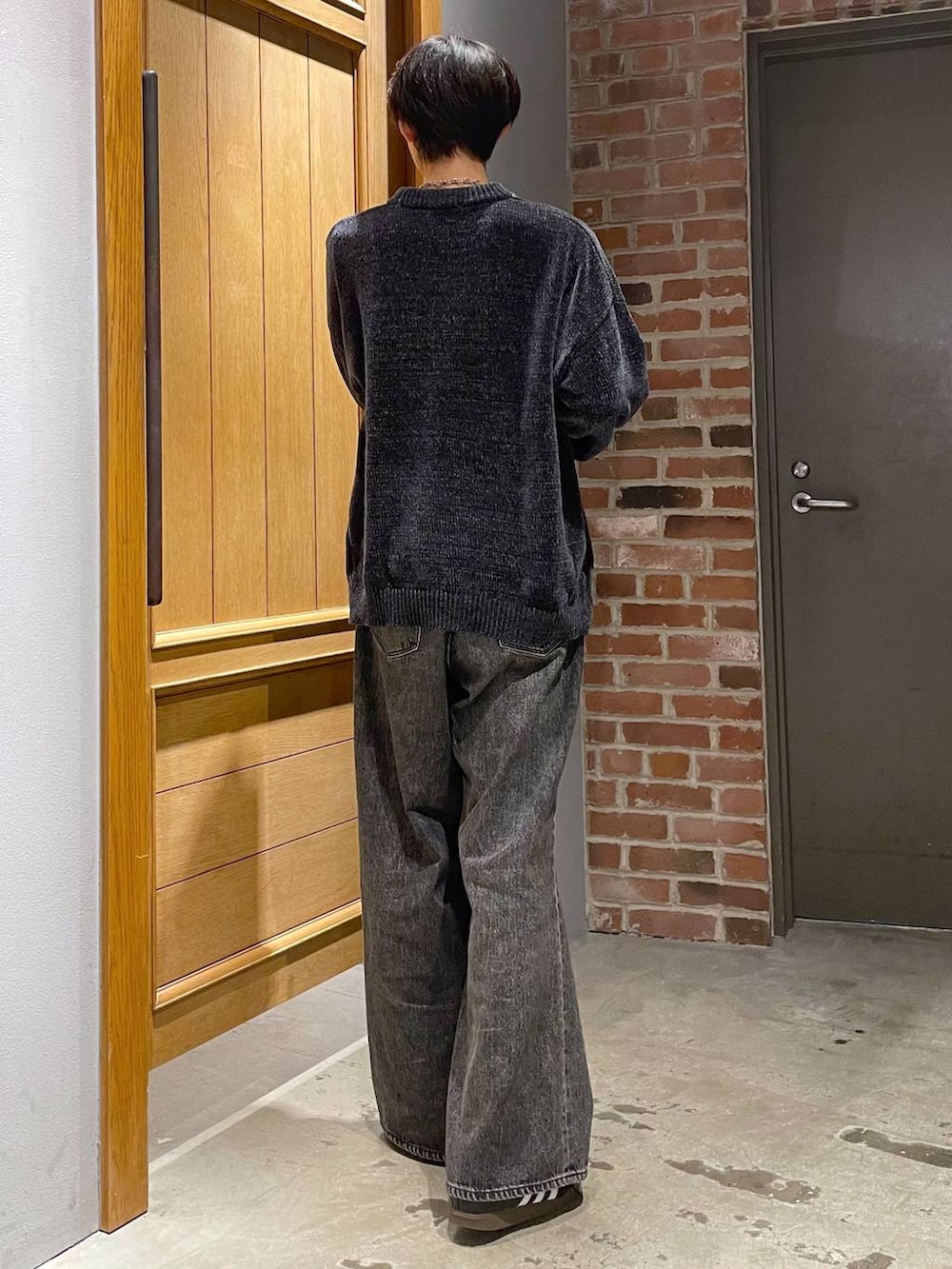 グレー系のデニムパンツ、ブラック系のニット/セーターを着用したメンズの秋コーディネートの3枚目の写真