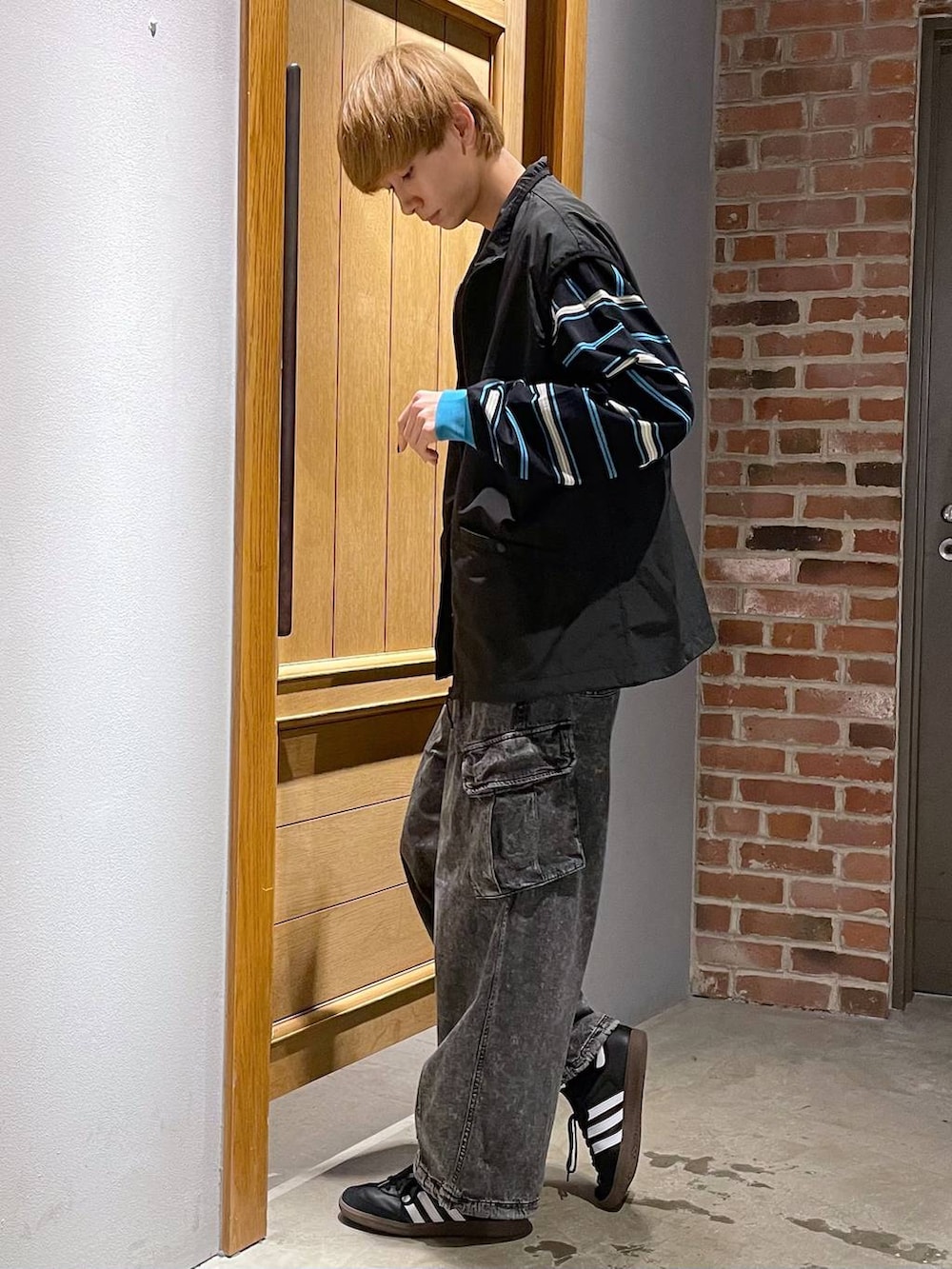 ブラック系のTシャツ/カットソー、グレー系のカーゴパンツ、ブラック系のベストを着用したメンズの春コーディネートの2枚目の写真