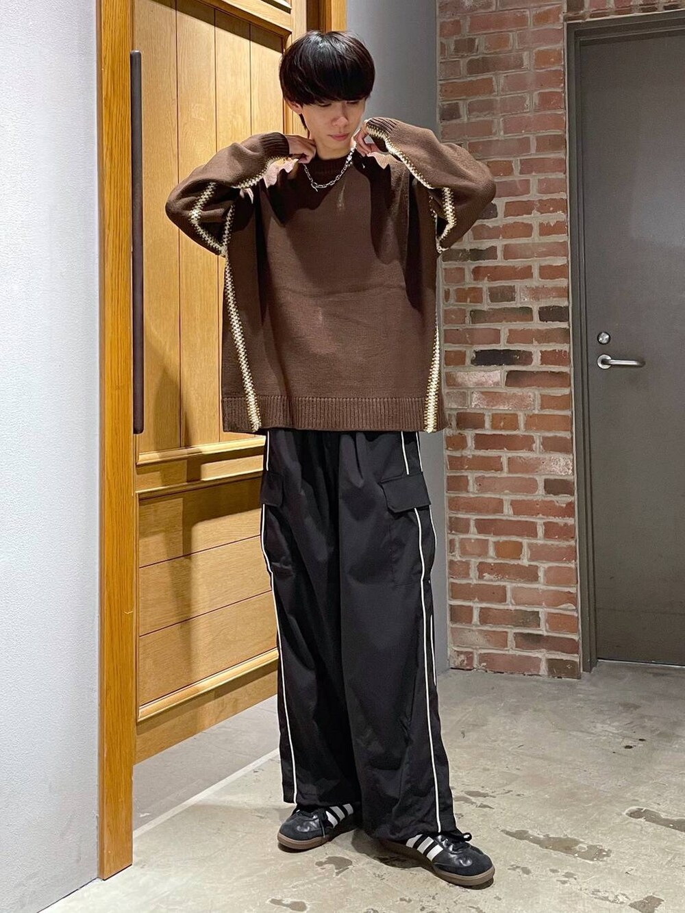 ブラック系のカーゴパンツ、ブラウン系のニット/セーターを着用したメンズの秋コーディネートの2枚目の写真