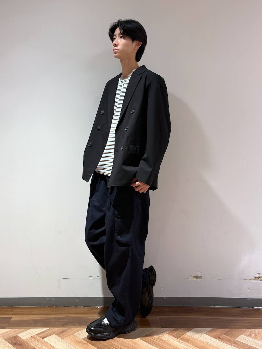 ブラック系のテーラードジャケット、ブラック系のローファー、ブルー系のTシャツ/カットソーを着用したメンズの春コーディネートの3枚目の写真