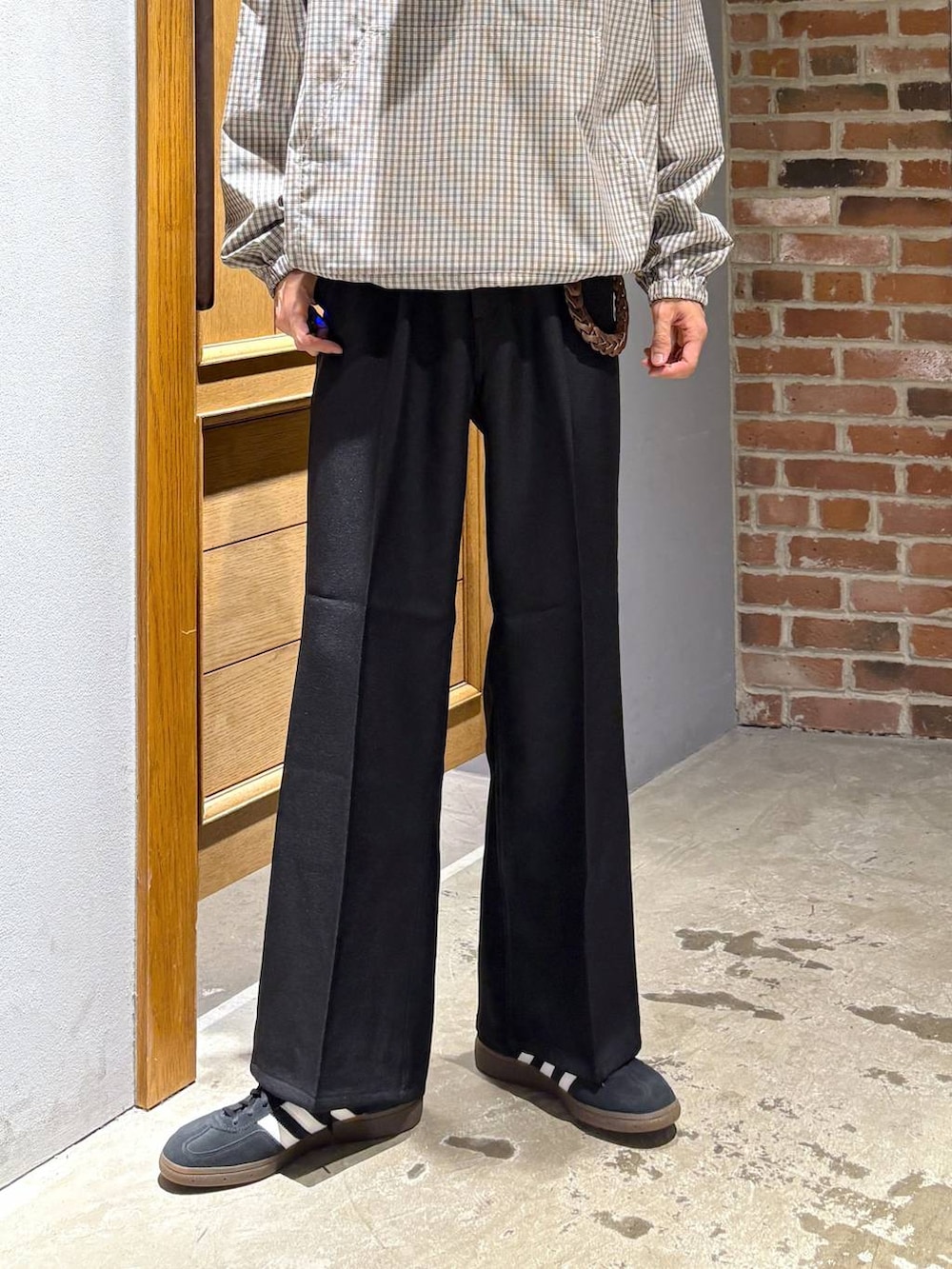 ブラック系のスニーカー、ブラック系のスラックス、ベージュ系のパーカーを着用したメンズの秋コーディネートの3枚目の写真