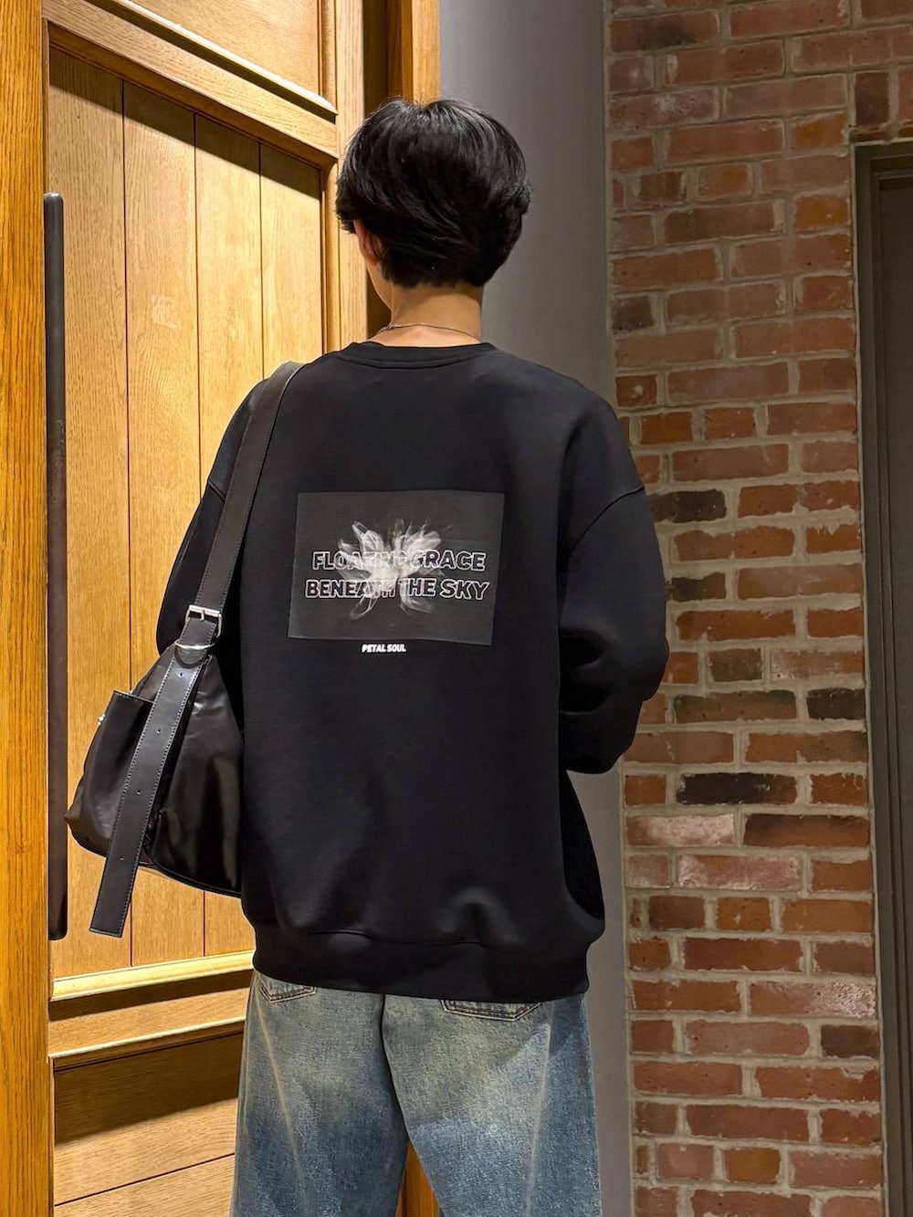 ブラック系のスニーカー、その他のショルダーバッグ、ブルー系のデニムパンツを着用したメンズの秋コーディネートの2枚目の写真