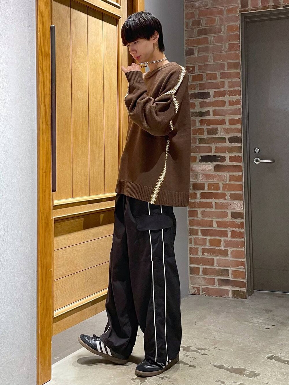 ブラック系のカーゴパンツ、ブラウン系のニット/セーターを着用したメンズの秋コーディネートの4枚目の写真