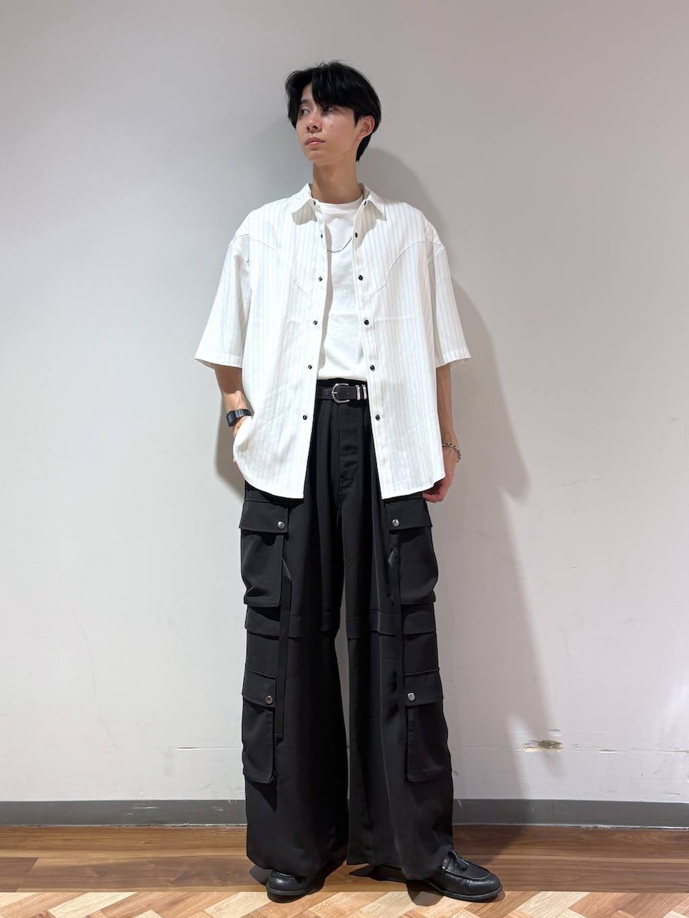ブラック系のローファー、ホワイト系のTシャツ/カットソー、ブラック系のカーゴパンツを着用したメンズの夏コーディネートの6枚目の写真