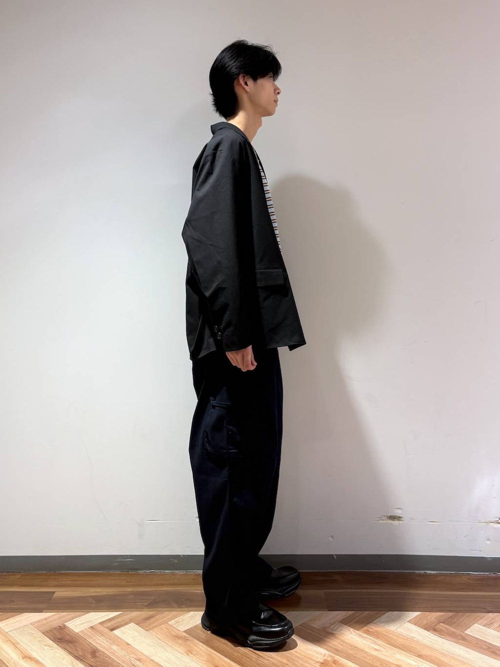 ブラック系のテーラードジャケット、ブラック系のローファー、ブルー系のTシャツ/カットソーを着用したメンズの春コーディネートの4枚目の写真