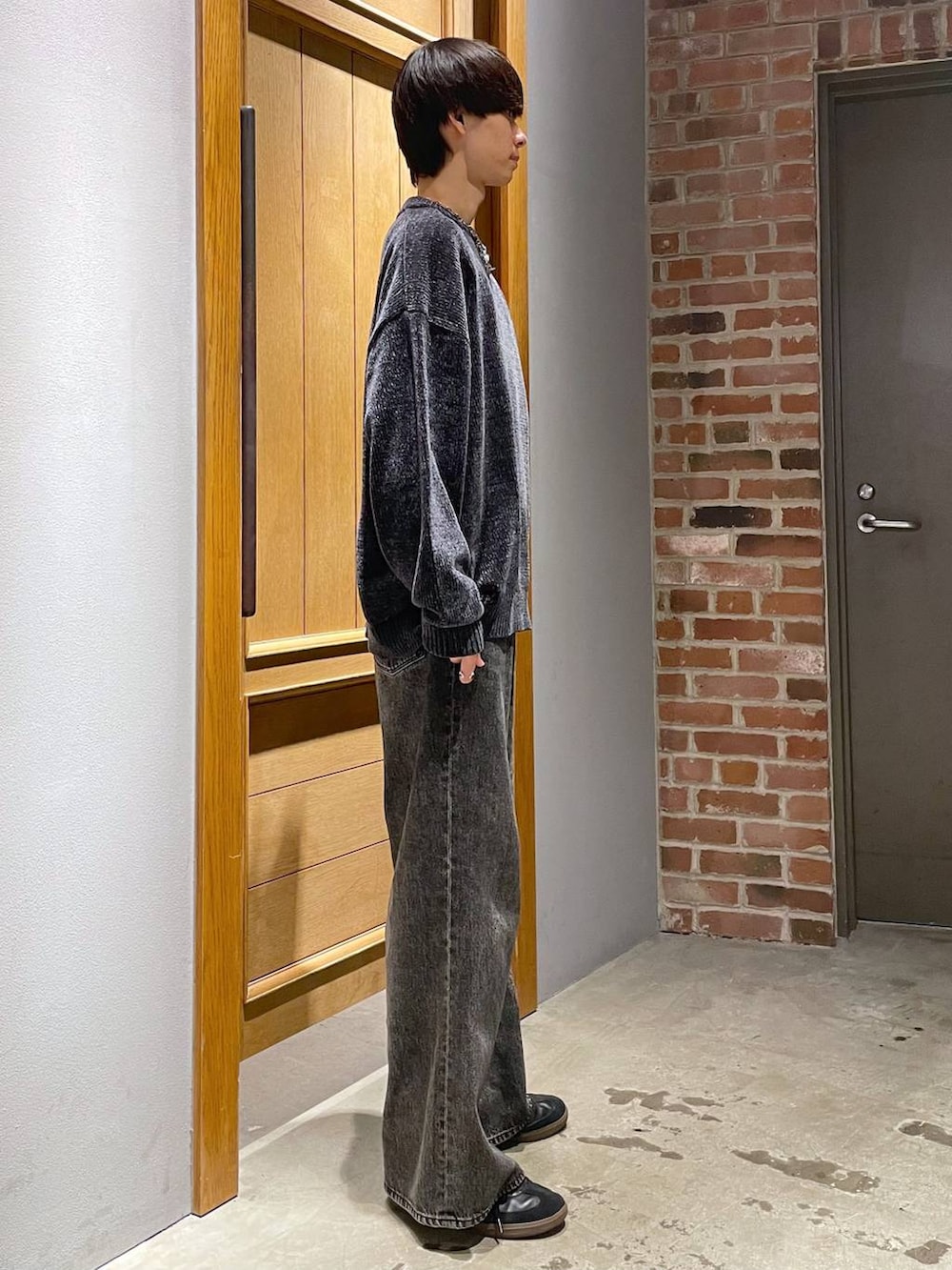 グレー系のデニムパンツ、ブラック系のニット/セーターを着用したメンズの秋コーディネートの2枚目の写真