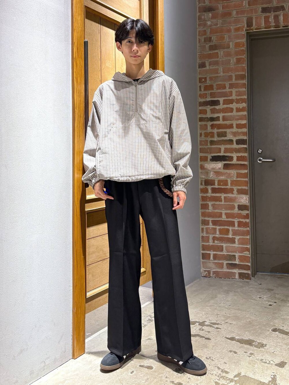 ブラック系のスニーカー、ブラック系のスラックス、ベージュ系のパーカーを着用したメンズの秋コーディネートの4枚目の写真