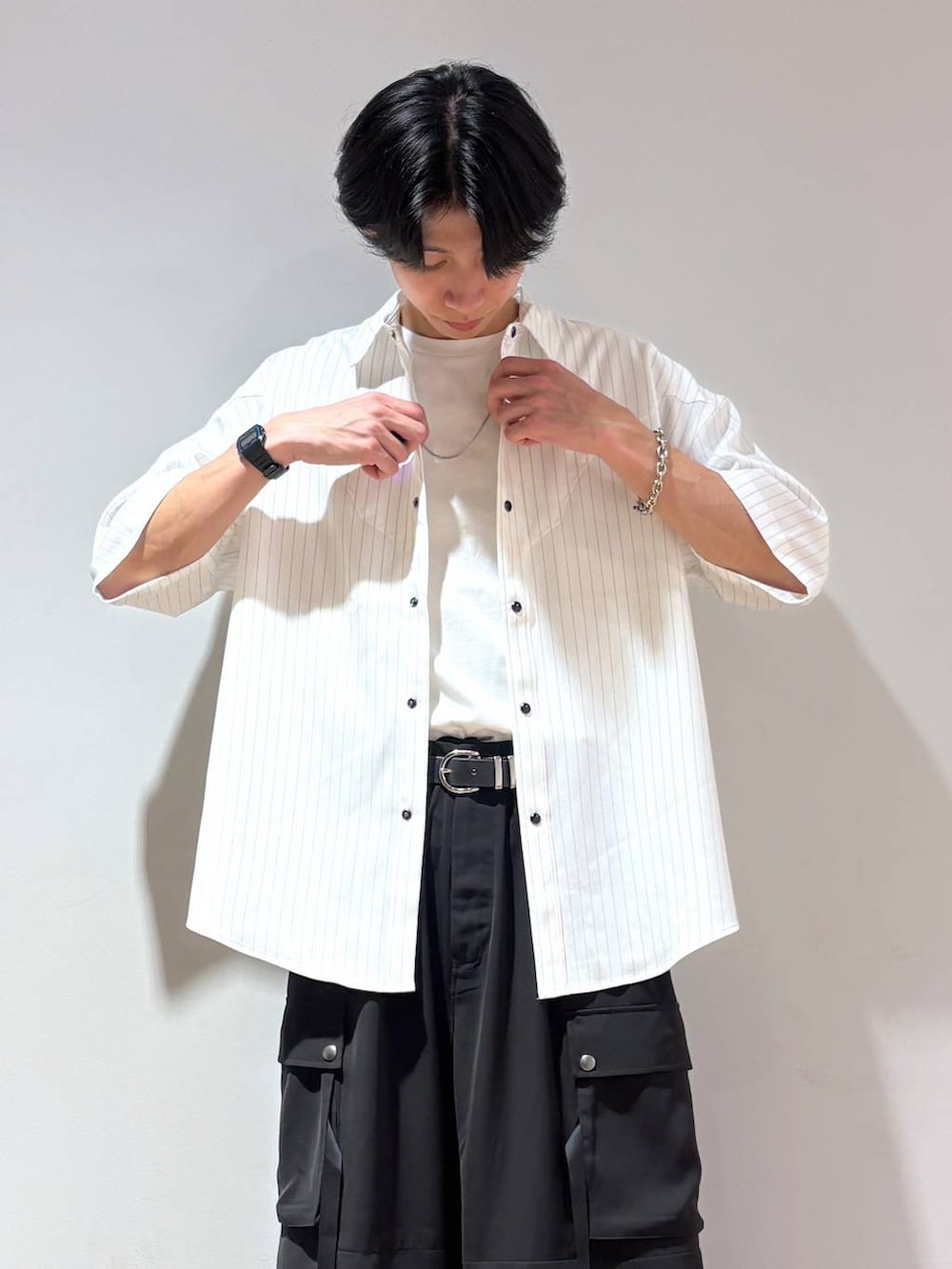ブラック系のローファー、ホワイト系のTシャツ/カットソー、ブラック系のカーゴパンツを着用したメンズの夏コーディネートの3枚目の写真