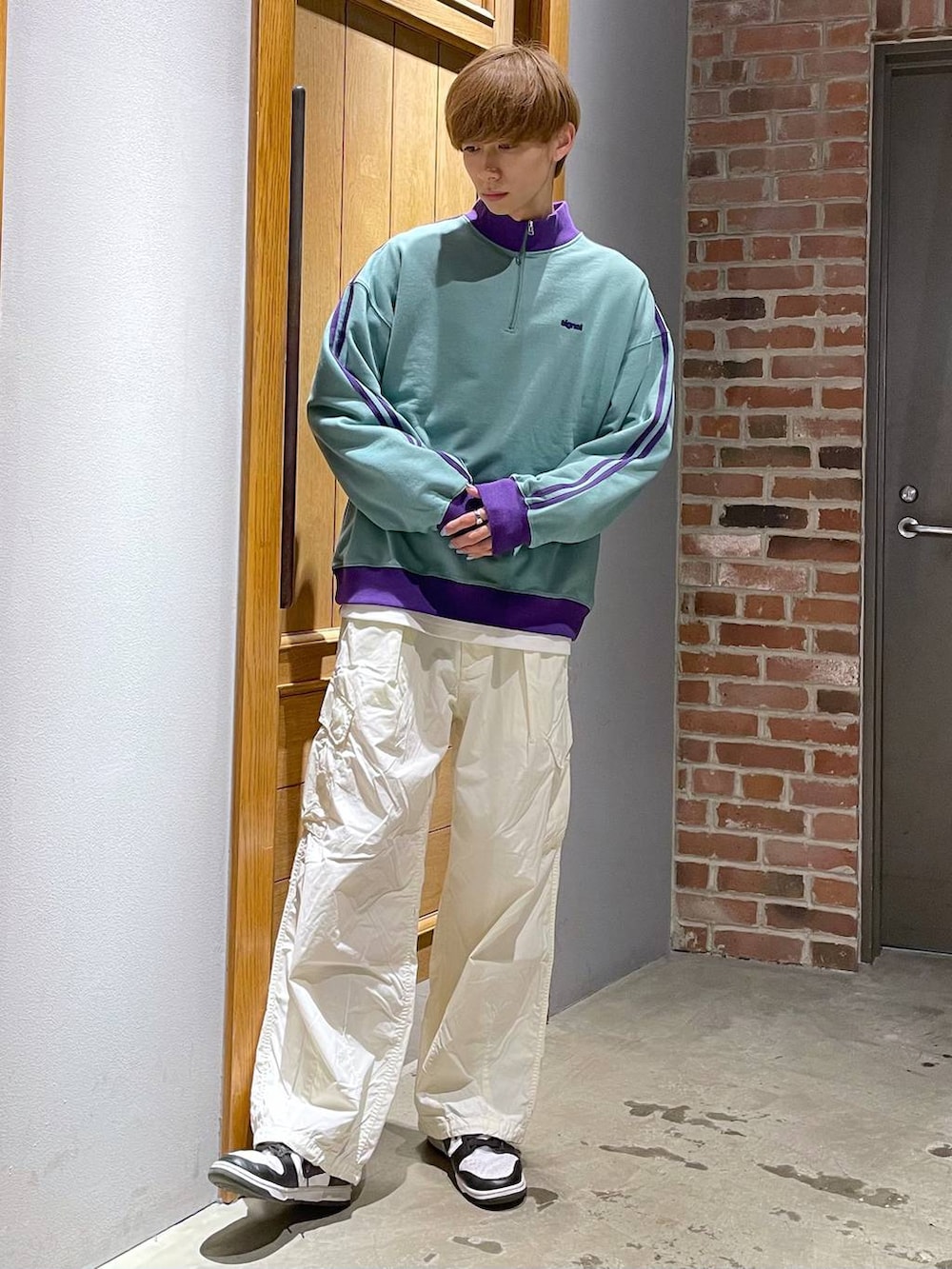 グリーン系のスウェット、ホワイト系のカーゴパンツを着用したメンズの春コーディネートの3枚目の写真