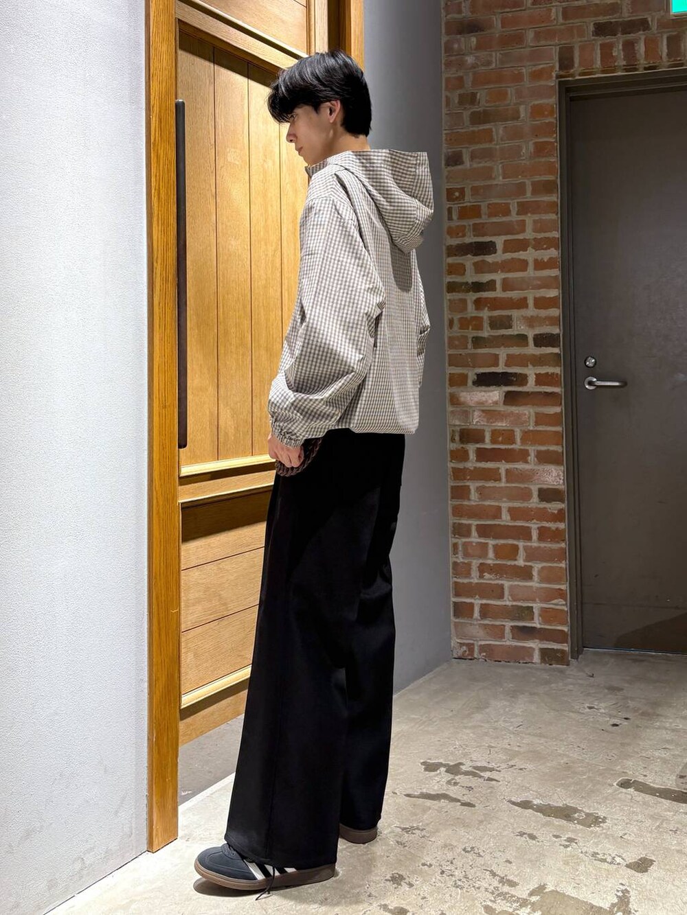 ブラック系のスニーカー、ブラック系のスラックス、ベージュ系のパーカーを着用したメンズの秋コーディネートの5枚目の写真