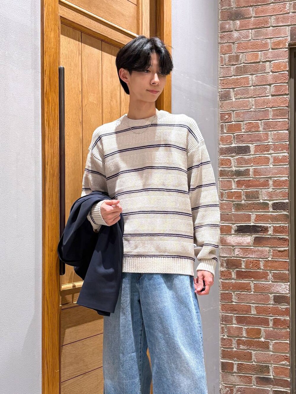 ブルー系のデニムパンツ、ブラック系のローファー、ブルー系のテーラードジャケットを着用したメンズの冬コーディネートの2枚目の写真