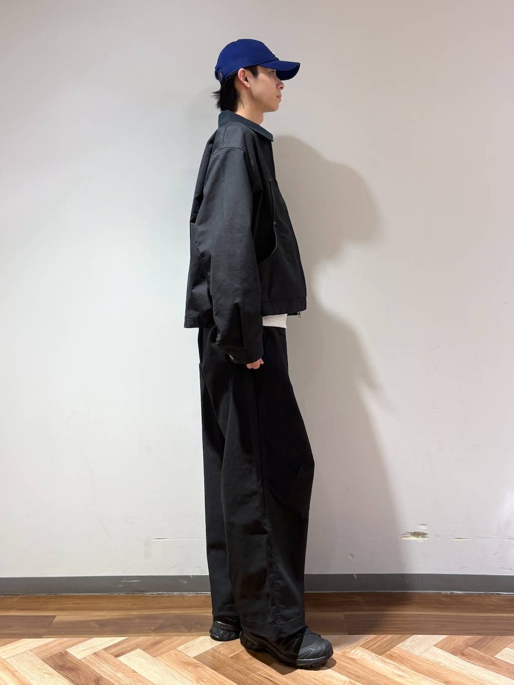 ブラック系のスニーカー、グレー系のスウェット、ブラック系のスラックスを着用したメンズの春コーディネートの5枚目の写真