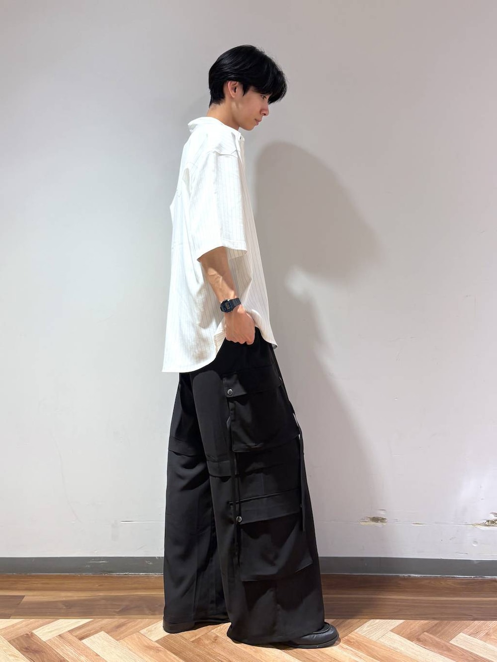 ブラック系のローファー、ホワイト系のTシャツ/カットソー、ブラック系のカーゴパンツを着用したメンズの夏コーディネートの4枚目の写真