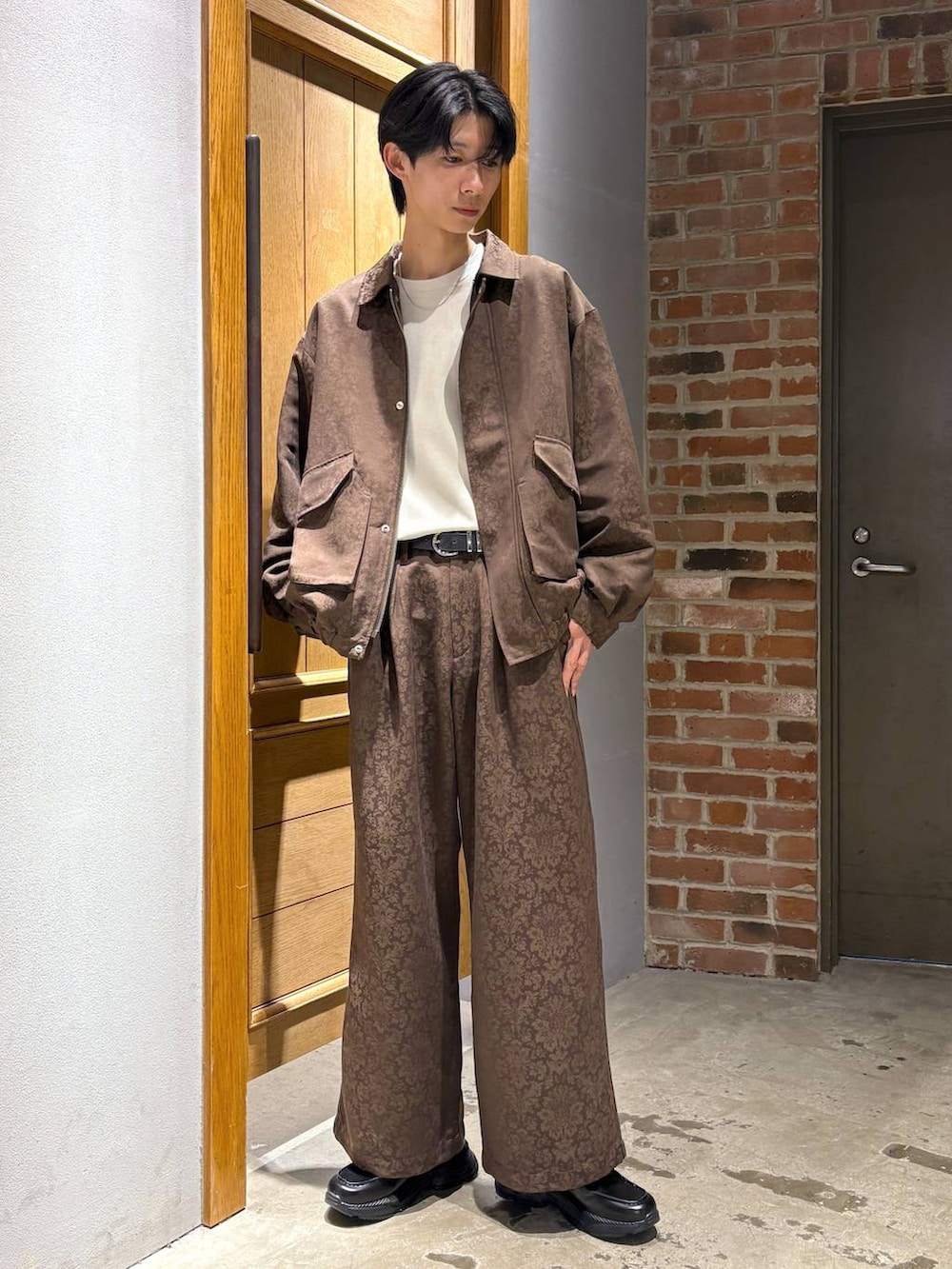 ホワイト系のスウェット、ブラック系のローファー、イエロー系のスラックスを着用したメンズの冬コーディネートの2枚目の写真