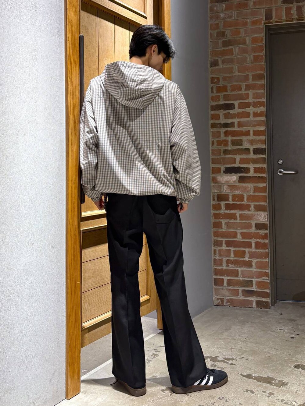 ブラック系のスニーカー、ブラック系のスラックス、ベージュ系のパーカーを着用したメンズの秋コーディネートの6枚目の写真