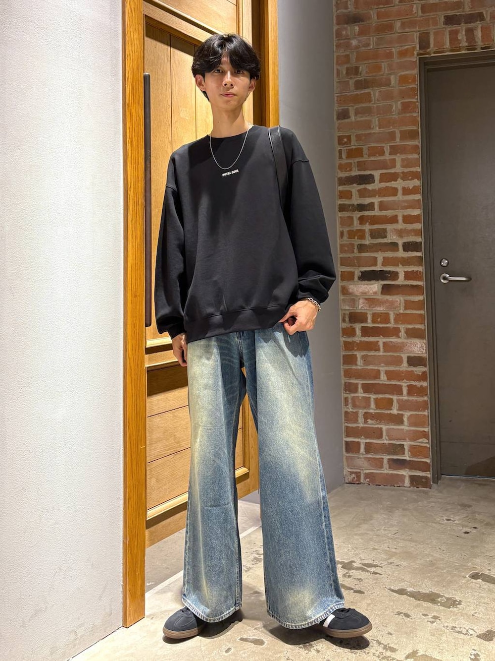 ブラック系のスニーカー、その他のショルダーバッグ、ブルー系のデニムパンツを着用したメンズの秋コーディネートの6枚目の写真