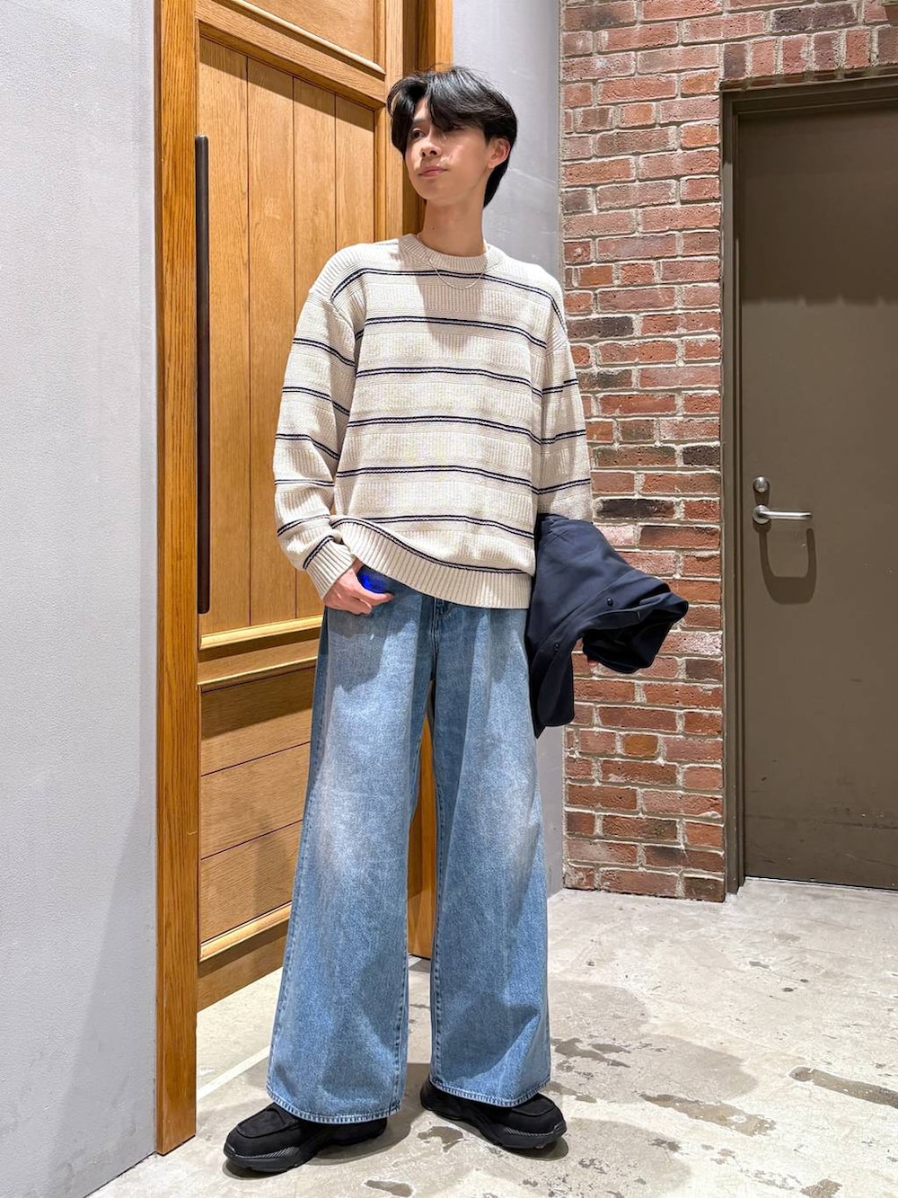 ブルー系のデニムパンツ、ブラック系のローファー、ブルー系のテーラードジャケットを着用したメンズの冬コーディネートの6枚目の写真