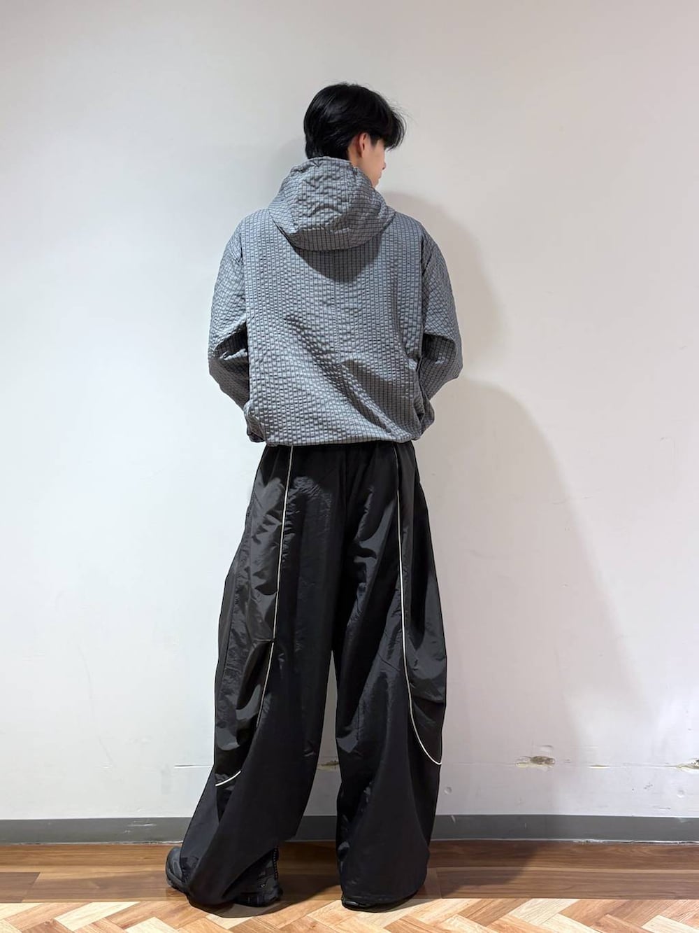 グレー系のブルゾン、ブラック系のその他パンツ、ブラック系のスニーカーを着用したメンズの秋コーディネートの4枚目の写真