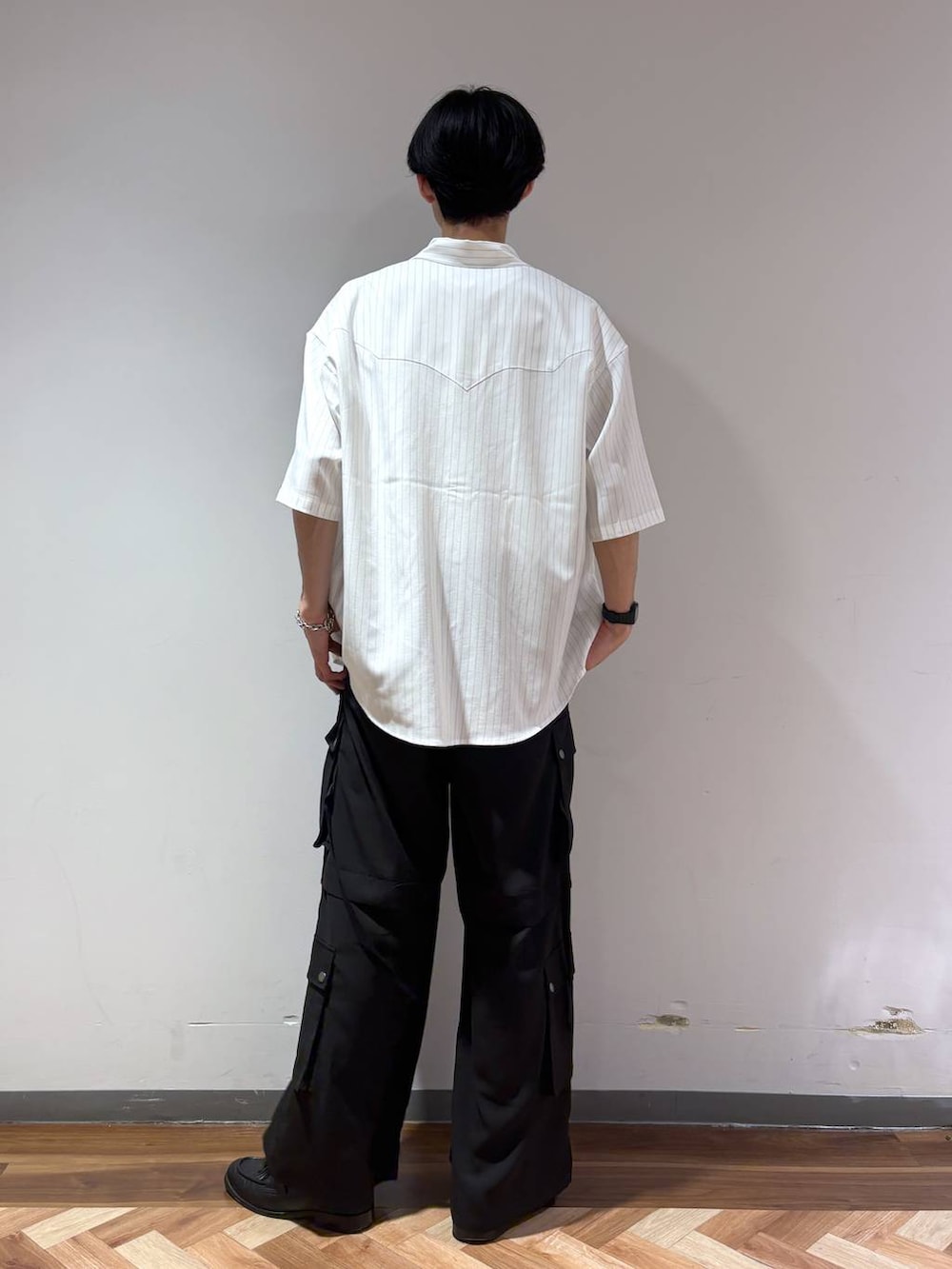 ブラック系のローファー、ホワイト系のTシャツ/カットソー、ブラック系のカーゴパンツを着用したメンズの夏コーディネートの5枚目の写真