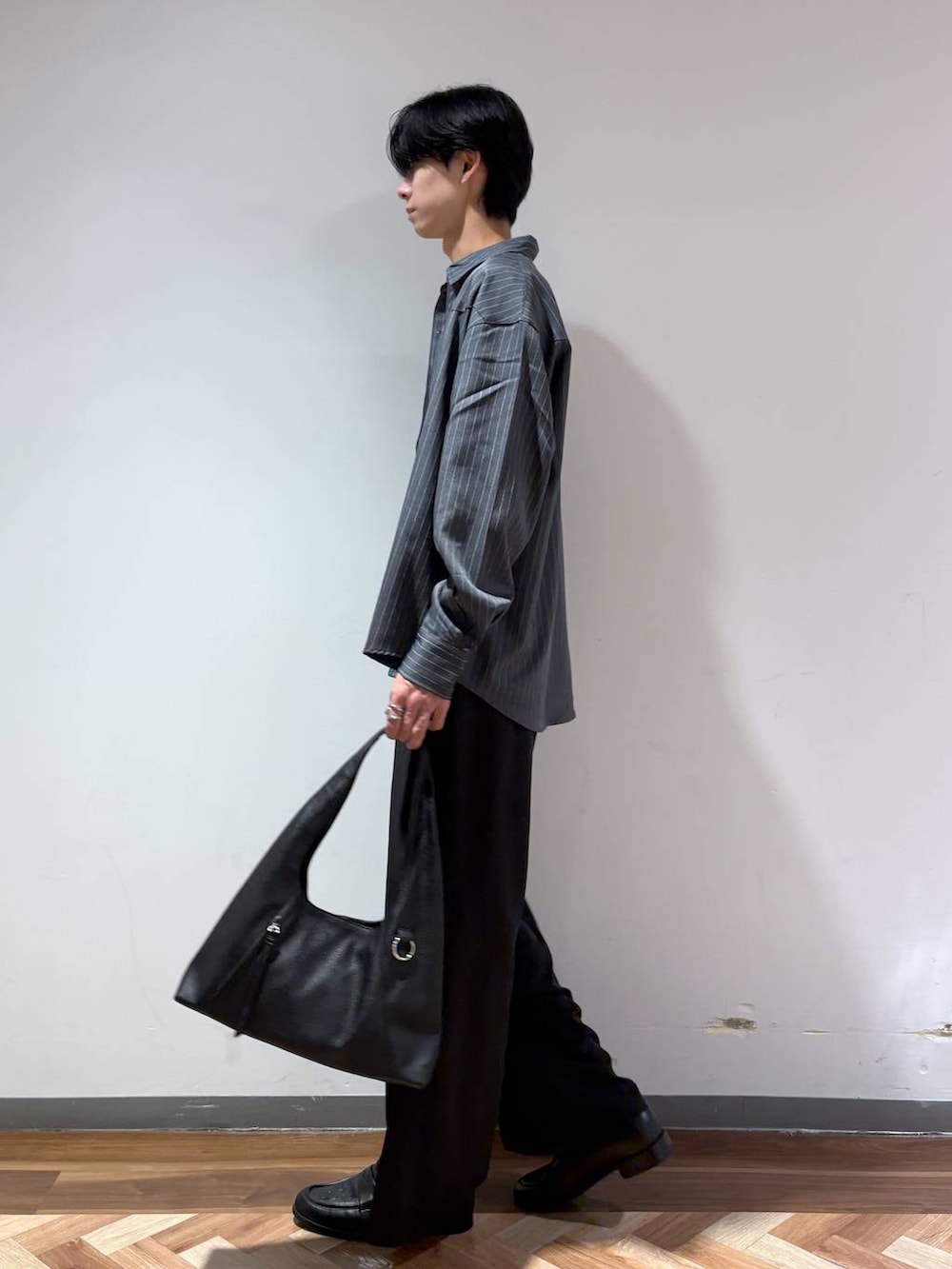 ブラック系のスラックス、グレー系のシャツ/ブラウス、ブラック系のローファーを着用したメンズの秋コーディネートの4枚目の写真