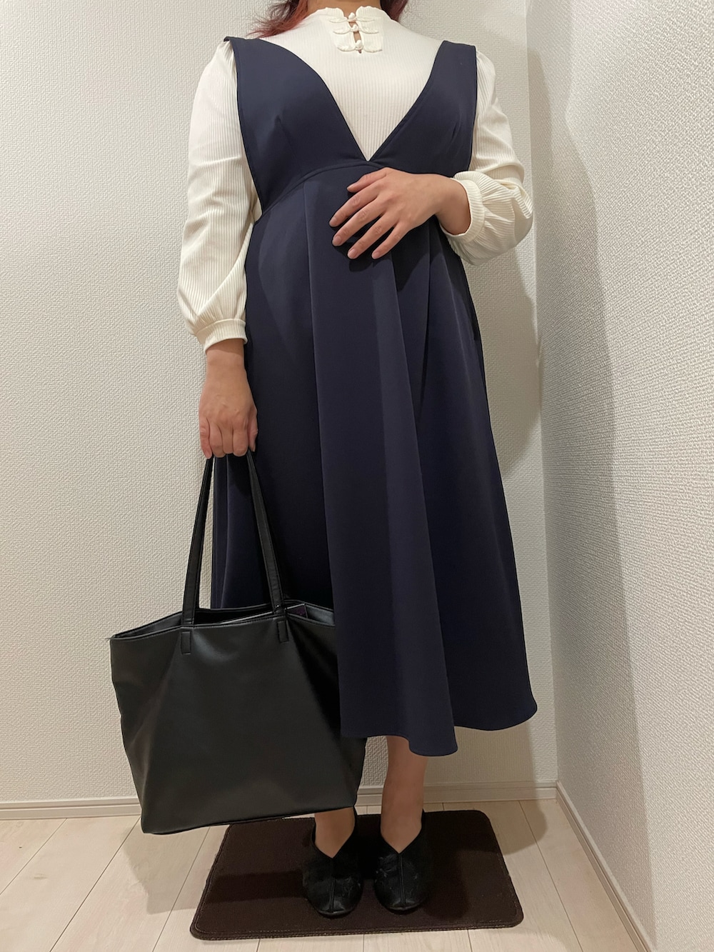 ブラック系のトートバッグ、ブラック系のその他シューズ、ブルー系のジャンパースカートを着用したレディースの春コーディネートの2枚目の写真