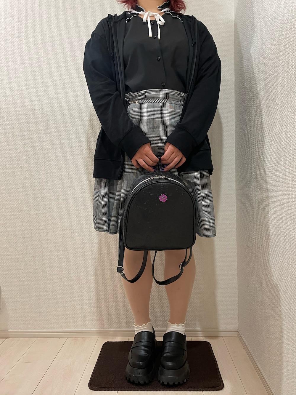 ブラック系のバックパック/リュック、ブラック系のローファー、ブラック系のスカートを着用したレディースの夏コーディネートの2枚目の写真