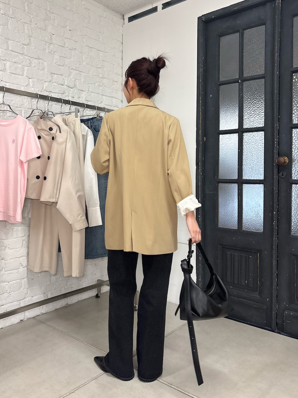 ブラック系のデニムパンツ、ベージュ系のテーラードジャケットを着用したレディースの冬コーディネートの2枚目の写真