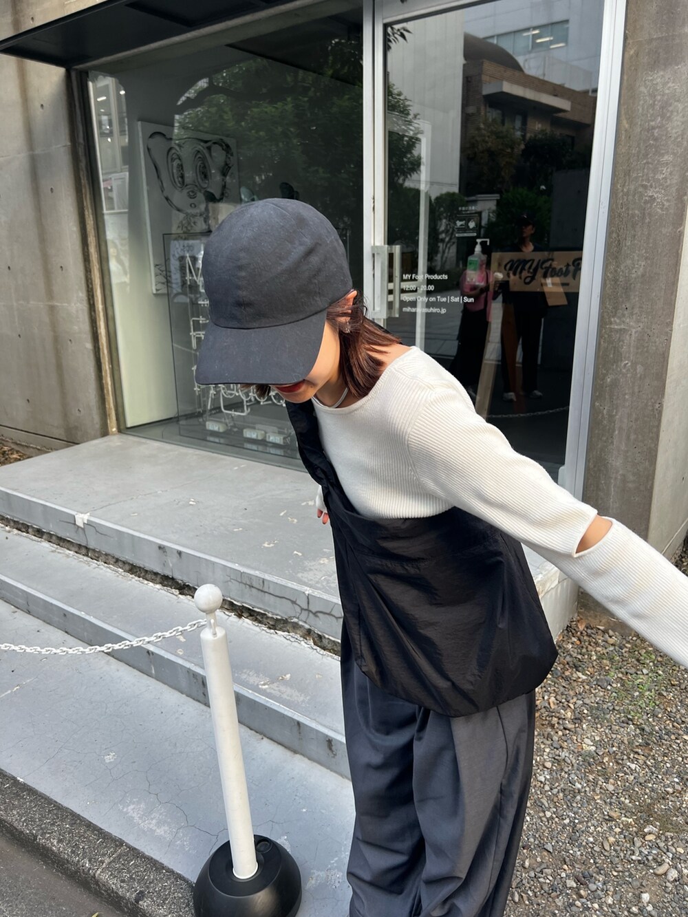 グレー系のその他パンツ、ホワイト系のニット/セーター、ブラック系のブーツを着用したレディースの秋コーディネートの2枚目の写真