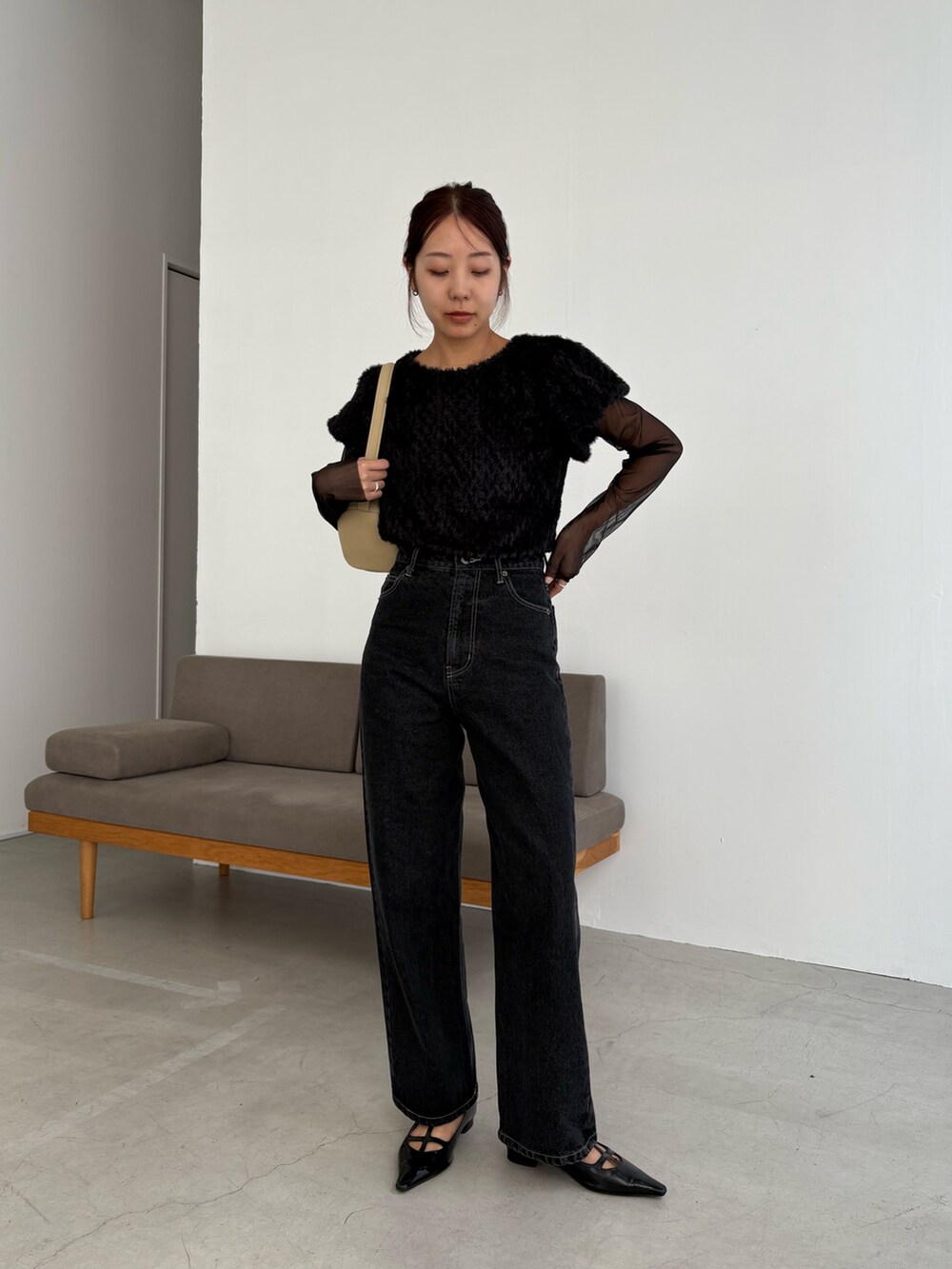 ブラック系のTシャツ/カットソー、ブラック系のデニムパンツを着用したレディースの秋コーディネートの2枚目の写真