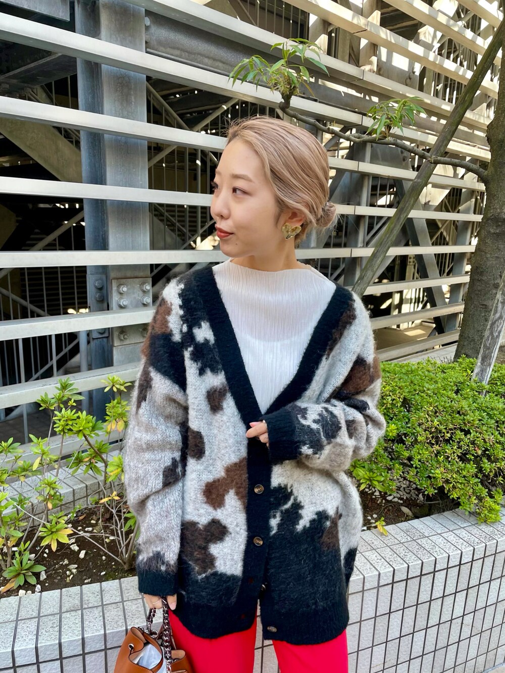 イエロー系のショルダーバッグ、レッド系のその他パンツ、ホワイト系のブーツを着用したレディースの秋コーディネートの2枚目の写真