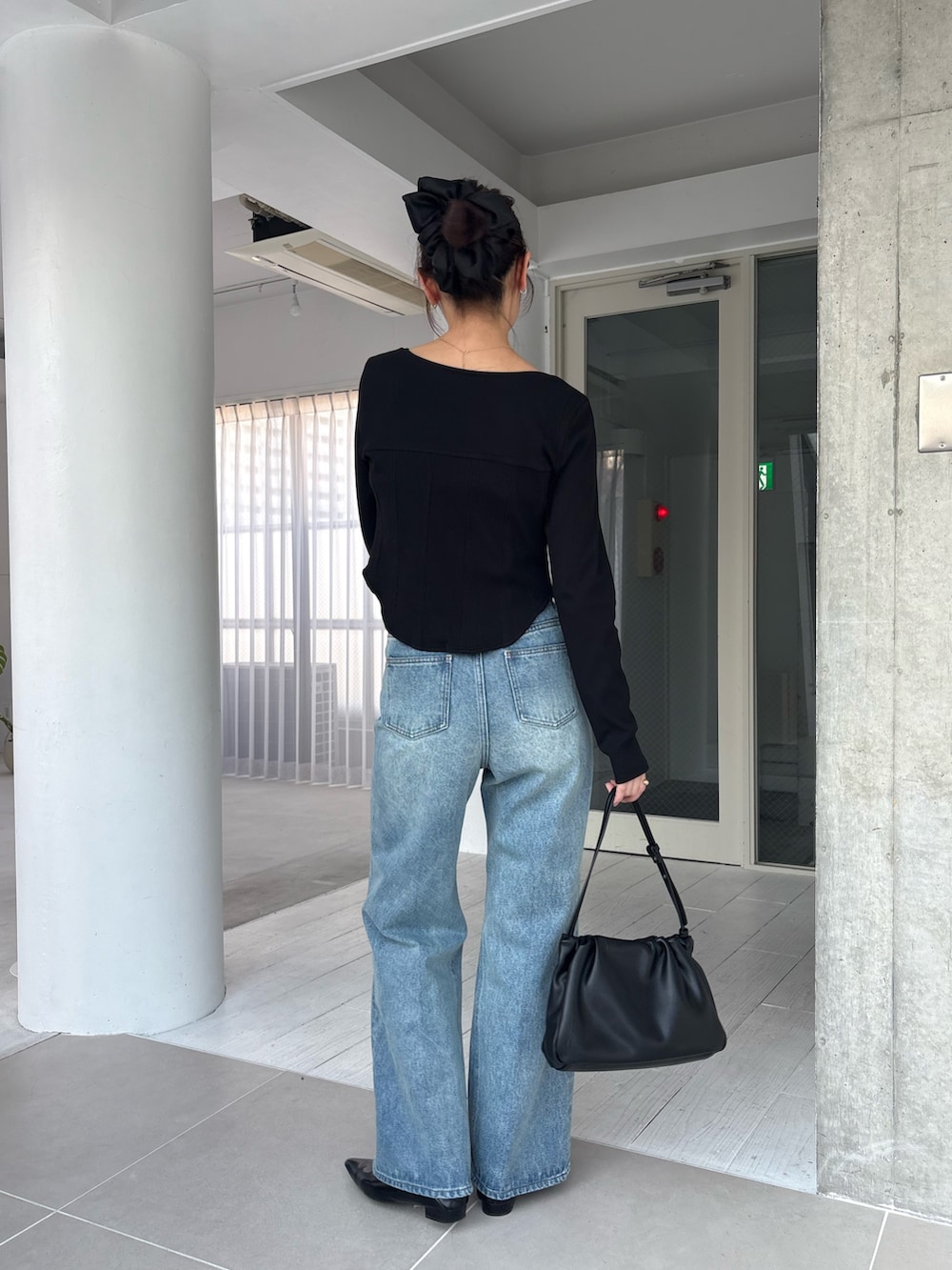 ブラック系のTシャツ/カットソー、ブルー系のデニムパンツを着用したレディースの春コーディネートの3枚目の写真