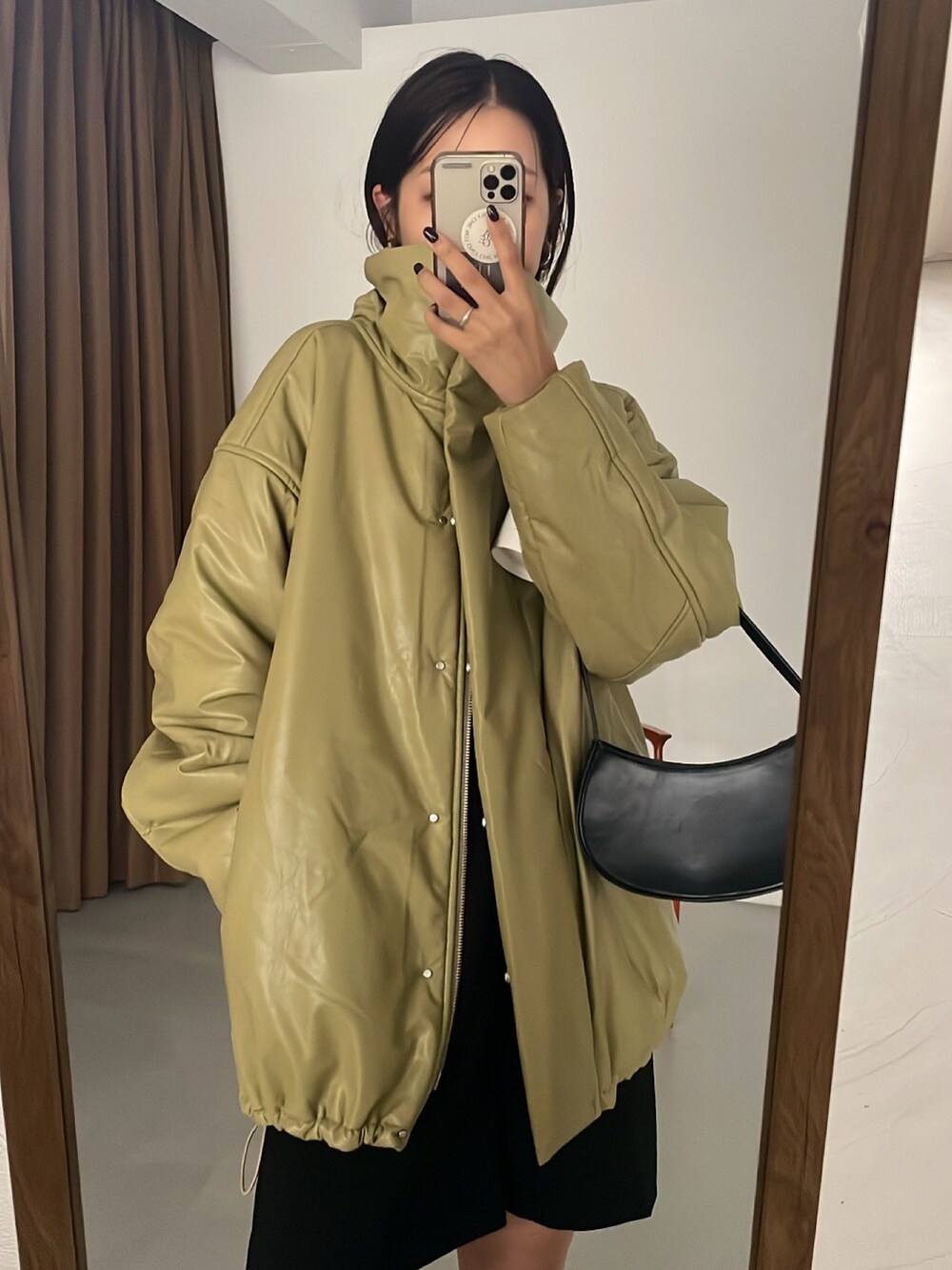 グリーン系のダウンジャケット/コート、ブラック系のパンツを着用したレディースの秋コーディネートの3枚目の写真