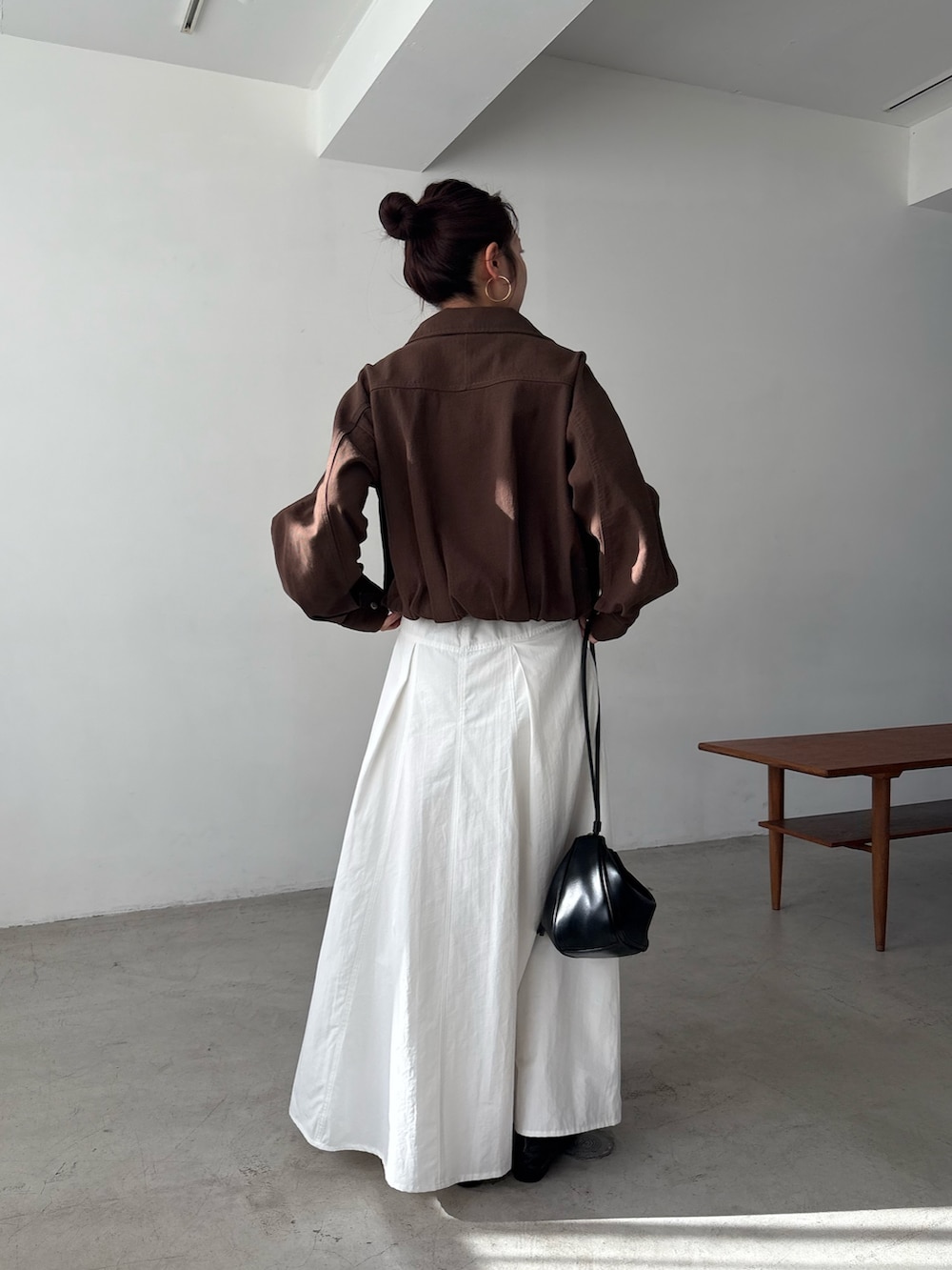 ホワイト系のスカート、ブラウン系のブルゾンを着用したレディースの冬コーディネートの3枚目の写真