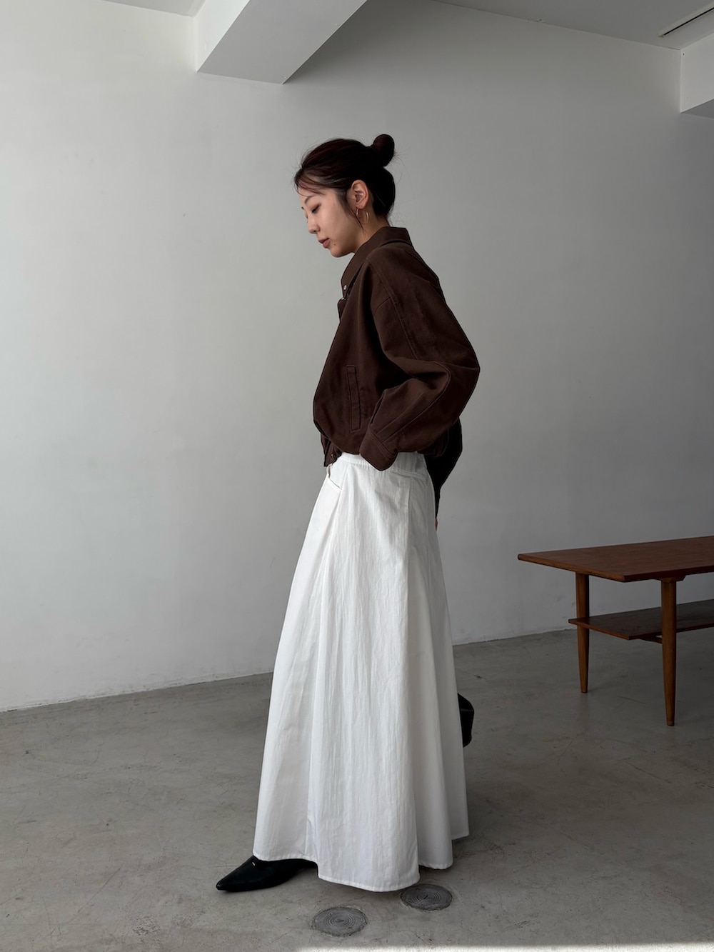 ホワイト系のスカート、ブラウン系のブルゾンを着用したレディースの冬コーディネートの2枚目の写真