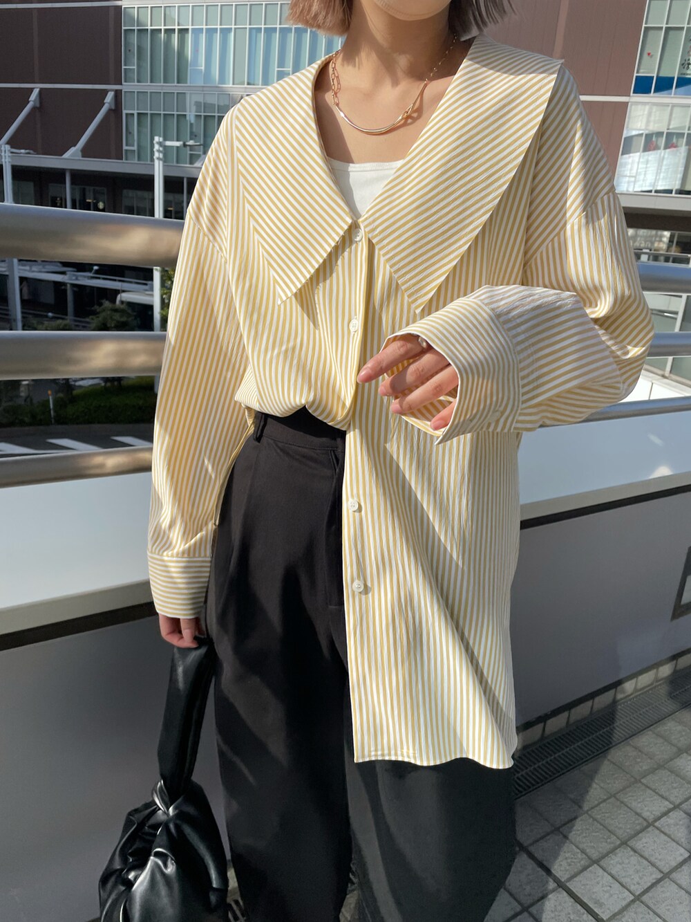 イエロー系のシャツ/ブラウス、ブラック系のその他パンツ、ピンク系のスニーカーを着用したレディースの春コーディネートの2枚目の写真