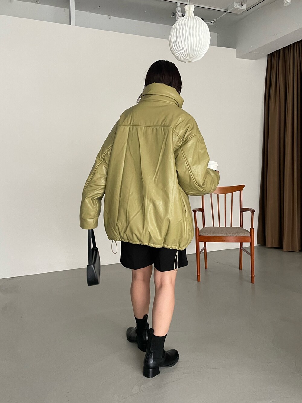 グリーン系のダウンジャケット/コート、ブラック系のパンツを着用したレディースの秋コーディネートの2枚目の写真