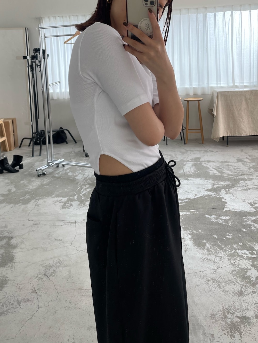 ブラック系のスウェットパンツ、ホワイト系のTシャツ/カットソー、ブラック系のスニーカーを着用したレディースの春コーディネートの2枚目の写真