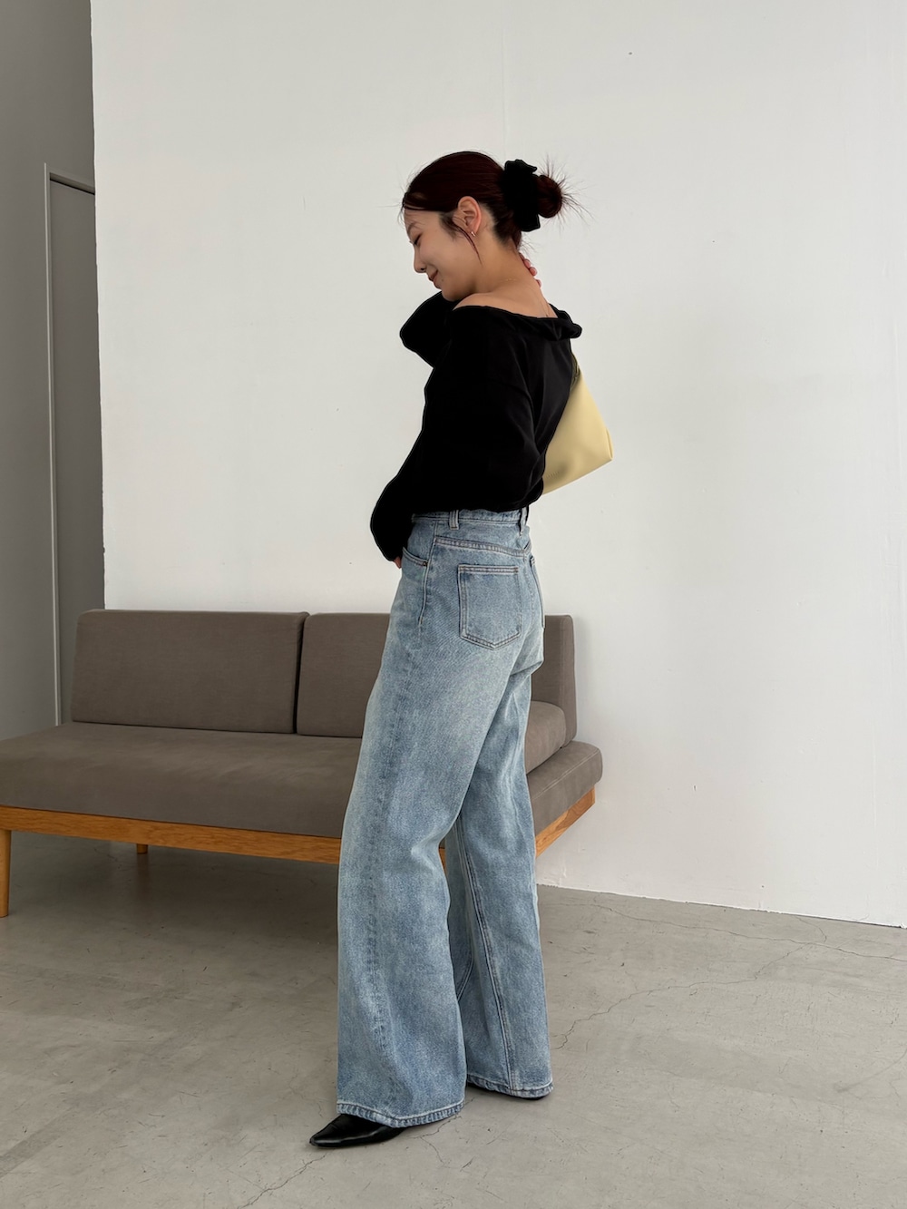 ブルー系のデニムパンツ、ブラック系のTシャツ/カットソー、イエロー系のショルダーバッグを着用したレディースの春コーディネートの2枚目の写真