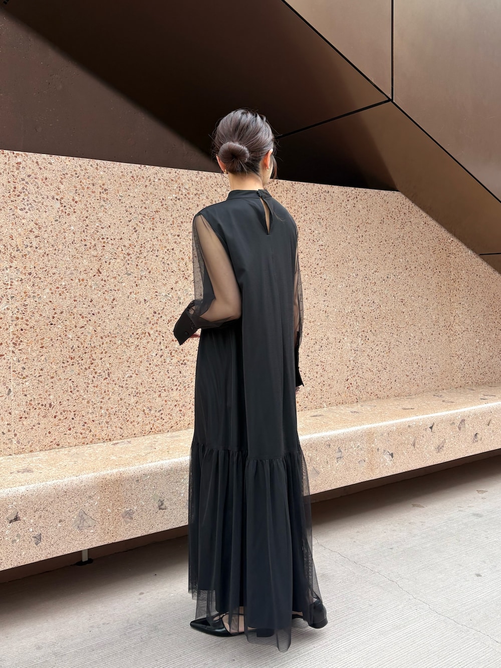 ブラック系のワンピース、ホワイト系のショルダーバッグを着用したレディースの春コーディネートの2枚目の写真