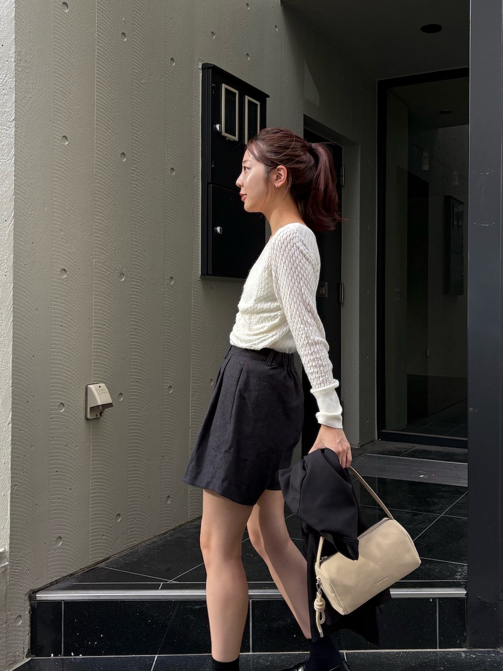 グレー系のその他パンツ、ホワイト系のニット/セーター、ブラック系のローファーを着用したレディースの秋コーディネートの3枚目の写真